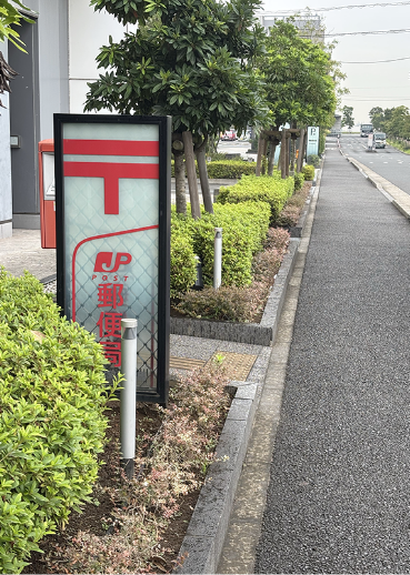 左手にある立て看板 郵便局の写真
