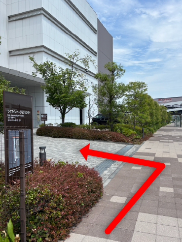 低木を挟んだ左手に見える看板 ライフイノベーションセンターの写真